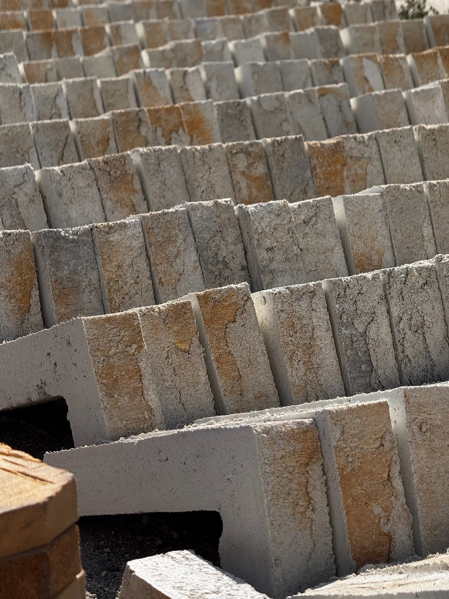 Вироби GoodBrick стоять рядами на ребрі на майданчику виробництва, попереду кутові елементи